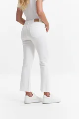 Jean straight de tiro medio, color azul denim, con corte recto y ruedo desflecado.