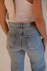 Jean celeste de tiro alto, corte wide leg y rotura en la rodilla.