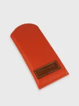 Funda porta lentes color naranja confeccionada 100% en cuero con costuras a tono y etiqueta de cuero marrón con el logo de la marca Trancuerta.