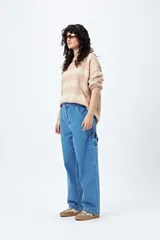 Pantalón jean negro de corte amplio y estilo carpenter, con tiro medio, bolsillos utilitarios y presillas laterales.