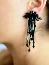 Caravanas colgantes de diseño tipo cascada, compuestas por múltiples cuentas de cristal facetado en color negro.