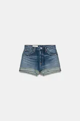Shorts de jean azul medio, tiro alto, con cinco bolsillos y bajo desflecado con vuelta.