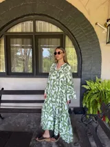 Vestido largo de corte amplio con estampado abstracto en tonos verde y blanco, escote en V y mangas largas acampanadas. Cierre frontal con botones. 