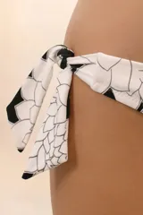 Calzón de bikini negro con estampado de flores blancas y lazos ajustables en los laterales.