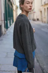 Chaqueta de punto gris oscuro con escote en pico, manga larga y cierre frontal con tres botones.