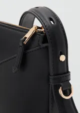 Cartera bandolera de poliuretano color negro, con diseño estructurado, costuras decorativas en V en el frente y cierre superior metálico dorado.