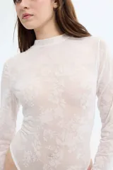 Body blanco de encaje floral con cuello alto y mangas largas.