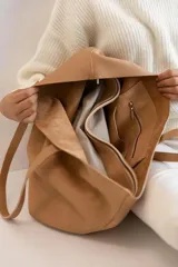 Bolso tote de cuero color tostado, con doble asa de hombro y diseño minimalista. Incluye un bolsillo separador extraíble.