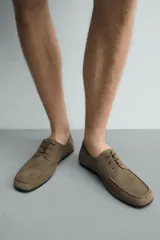 Zapato de vestir para hombre de piel con acabado en gamuza, color verde militar, punta redonda y cordones al tono.