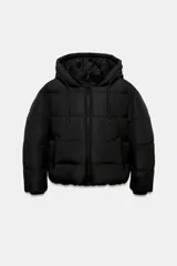 Anorak acolchado de corte corto en color negro, con capucha ajustable, cierre frontal de cremallera y bolsillos laterales. Cuenta con puños interiores y bajo ajustable con cordones elásticos.