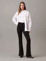 Leggings negros de punto milano con talle alto, corte slim, pierna acampanada y bajo abierto. Confeccionados con un 66% de viscosa, 30% de nailon y 4% de elastano.