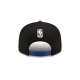 Gorro snapback New Era 9FIFTY con corona negra y visera azul. Presenta el logo de los Golden State Warriors bordado en el frente en amarillo y azul.
