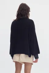 Sweater de punto negro con cuello bote y mangas evasé, confeccionado en algodón con diseño holgado.