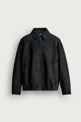 Cazadora de piel con acabado serraje de corte relaxed fit, color negro, con cuello solapa, bolsillos de vivo en la cadera, bajo elástico y cierre frontal con cremallera de doble dirección. Colección especial Aaron Levine x ZARA.