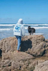 Hoodie de color celeste con capucha, confeccionado en tejido de algodón. Presenta un diseño bordado en la espalda con motivos florales y texto en tonos azules.