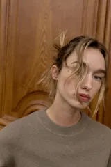 Jersey de punto liso con cuello redondo y manga larga, con detalle de costura en forma de V en el cuello.