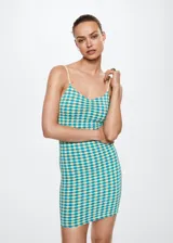 Vestido corto entallado de tejido elástico con textura, estampado geométrico en tonos turquesa y amarillo, escote en pico y tirantes finos.