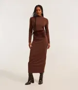 Vestido midi marrón con cuello alto y mangas largas. Presenta un detalle de encaje en la parte trasera y una faja de terciopelo en la cintura.