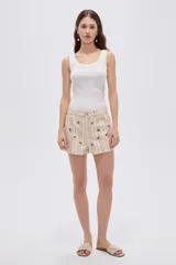 Short de algodón beige con diseño a rayas verticales y pequeño estampado de flores, con bolsillos laterales y cierre frontal con botón y cremallera.