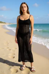 Vestido largo de tejido de punto calado color negro, con tirantes finos y escote recto. El tejido es transparente, mostrando la ropa interior o traje de baño debajo.