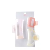 Pack de tres broches de pelo Miss Carol en tonos pastel iridiscentes. Incluye un broche rectangular grande en rosa claro, un broche cuadrado pequeño en rosa salmón y un broche curvo con detalle circular en beige.