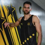 Musculosa deportiva Puma del equipo de básquet de Pefarol, modelo Away 2025. Disefo en color negro con detalles en amarillo, presenta el escudo del club en el pecho, el logotipo de Puma y una hilera de estrellas amarillas alineadas en diagonal en la parte inferior.