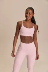 Conjunto deportivo de dos piezas en color rosado, compuesto por una calza larga de tiro alto y un top corto de tirantes finos.