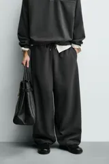 Pantalón de corte baggy fit confeccionado en tejido técnico, con cintura elástica ajustable mediante cordón y bajo con elásticos laterales para ajuste.