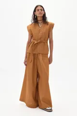 Pantalón palazzo color caramelo, de tiro alto y confeccionado en lino.