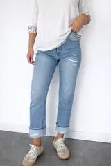 Pantalón de jean corte regular fit en color celeste claro. Presenta un diseño con pequeñas roturas frontales y botamanga con doblez, confeccionado en denim con elastano para mayor flexibilidad y comodidad.