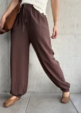 Pantalón de corte babucha color chocolate, de diseño holgado con cintura elástica fruncida y cordón ajustable.