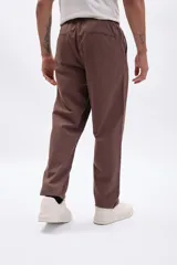 Pantalón de vestir color marrón, de corte recto y holgado, con cintura elastizada.