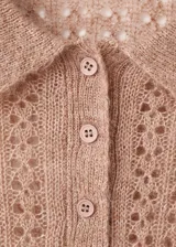 Polo de tejido de punto medio color marrón tostado, con diseño calado, manga larga y cuello con cierre de botones.