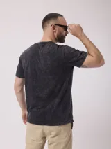 Remera color beige con cuello henley de tres botones y mangas cortas. Diseño estoneado.