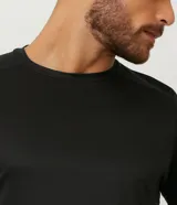 Remera deportiva de manga larga Get Over, color negro, con cuello redondo y diseño liso sin estampados. Confeccionada en tejido técnico de poliéster de secado rápido.