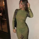 Vestido largo de microtul translúcido color verde con estampado geométrico abstracto, mangas largas y cuello redondo.