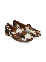 Mocasín Galeano confeccionado en cuero con pelo vacuno, con diseño de estampado animal print estilo vaca en tonos marrón y blanco, con suela plana y taco bajo de goma.