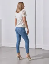 Blusa color blanco de crepe, marca Cable & Gauge. Cuello halter con detalles plisados y mangas cortas de encaje con destellos brillantes.