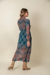 Vestido midi plisado de gasa estampada en tonos violeta y naranja, con lazo en el cuello y en la cintura.