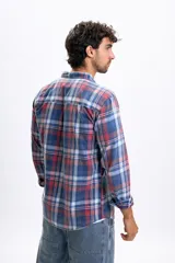 Camisa de manga larga con estampado de cuadros en tonos azules, rojos y blancos, con efecto lavado, cuello abotonado y bolsillo frontal.