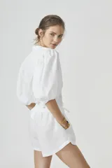 Camisa blanca de lino con cuello mao, mangas globo al codo y botones de nácar.