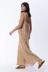 Vestido largo de tirantes en color crudo con estampa geométrica en tonos mostaza, de corte holgado y vuelo fluido.