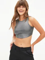 Crop top plateado de tejido acanalado, con cuello redondo y sisas anchas.