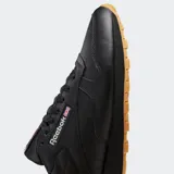 Championes Reebok Classic Leather de diseño minimalista, confeccionados en cuero negro con suela de goma color caramelo. Presentan cierre de cordones, entresuela de EVA y forro textil.
