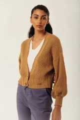 Saco de tejido de punto grueso color gris azulado, con cuello en V y manga larga abullonada. Presenta un solo botón de madera en la parte inferior delantera.