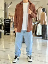 Sobrecamisa de pana color marrón chocolate, de manga larga, con cuello camisero, cierre frontal con botones y un bolsillo aplicado en el pecho.