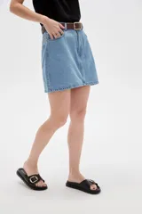 Minifalda de denim en color azul oscuro, con tiro alto, bolsillos delanteros y traseros, costuras en contraste y cierre frontal con botón y cremallera.