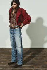 Cazadora de ante con cuello de solapa, cierre frontal cruzado con botones forrados y bajo elástico. Presenta mangas largas con trabillas en los puños y bolsillos laterales de vivo.