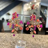 Aros colgantes hechos a mano con cristales rosas, fucsias, corales, plateados y violetas, unidos con alambre dorado.