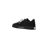 Championes Off-White Vulc Low en color negro, con el icónico logo de flechas cruzadas en contraste blanco en el lateral, cordones blancos y la característica brida roja de la marca.